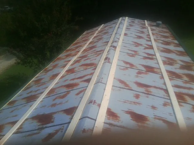 Rusted metal roof panels with new wood purlins before replacement — Storm Damage Roof Repair in Four Lakes by Roofing Brothers