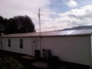 New metal roof on a single wide mobile home with a TV antenna in Four Lakes
