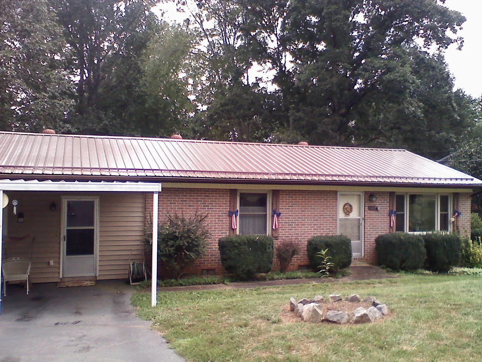 Bronze metal roof and carport on a brick ranch home — Roof Repair work by our crew in Four Lakes